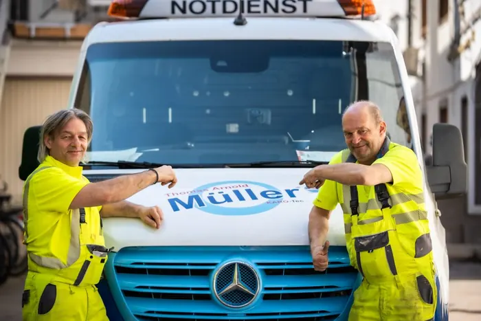 Zwei Mitarbeiter von KARO-Tec vor dem Notdienst-Fahrzeug