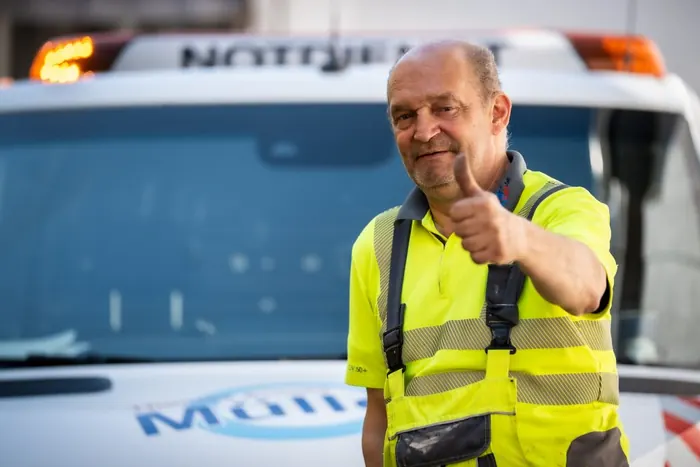 Mitarbeiter von KARO-Tec mit Daumen hoch vor dem Notdienst-Fahrzeug