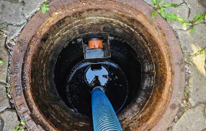 Saugschlauch im geöffneten Schacht eines Abscheiders